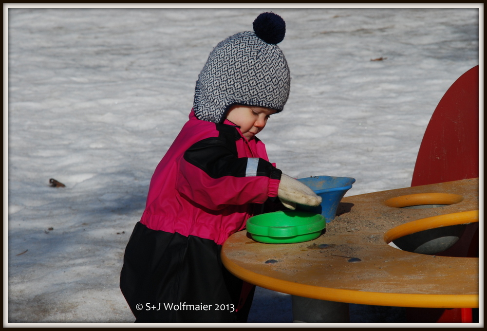 Our daughter playing in the snow, with sand. She is now really enjoys playing at the playground. 